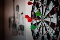 Close-up of a dartboard with multiple darts hitting the target, emphasizing precision and focus.